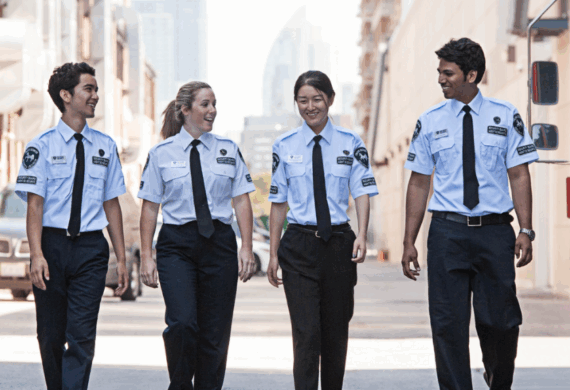 a groups of iron horse security guards walking down the street past a Canada post truck