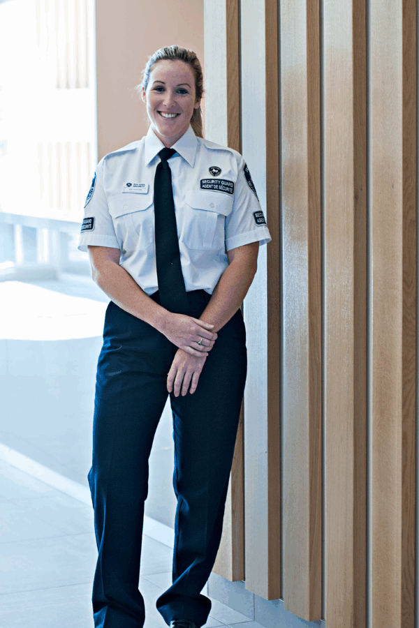Female security guard with a welcoming smile outside a commerical building