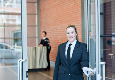 Female concierge opening door