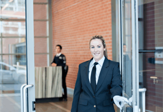 Guard assisting visitor with wayfinding at reception desk