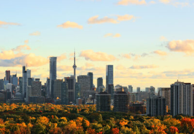 Toronto skyline with downtown, midtown, and urban tree canopy lit by setting sun in October 2016