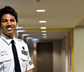 male iron horse security guard in concierge uniform in the hallway of a residence building