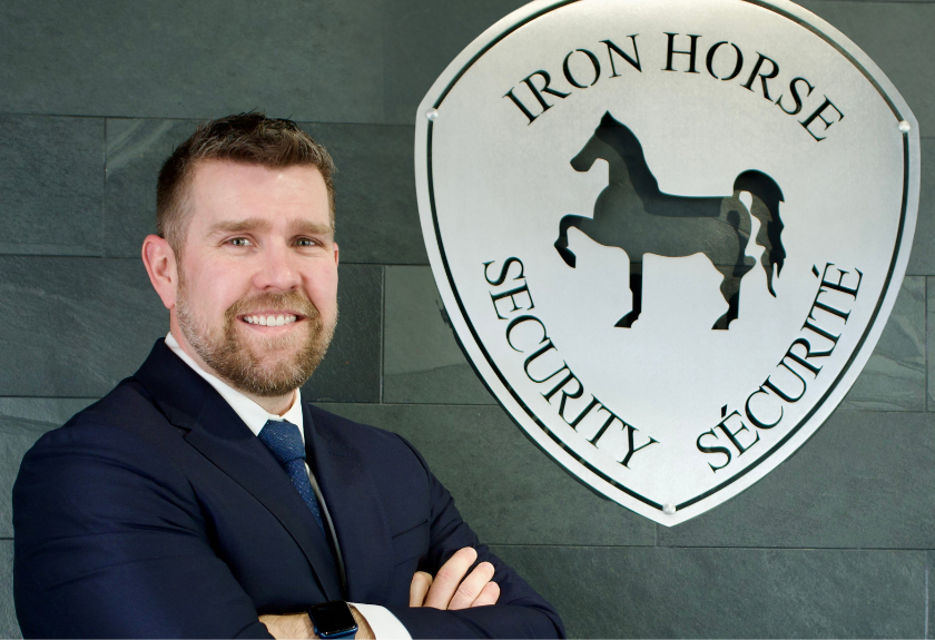 Justin Ferns CEO of Iron Horse Security standing in front of the logo